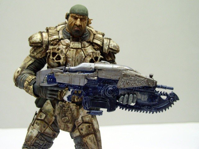 Figurine de Marcus Fenix en armure tenant un fusil Lancer bleu et gris