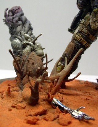 Diorama de la figurine Marcus Fenix sur socle martien avec créatures organiques et arme