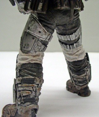 Détail des jambes et bottes blindées de la figurine Marcus Fenix peinte en gris vieilli