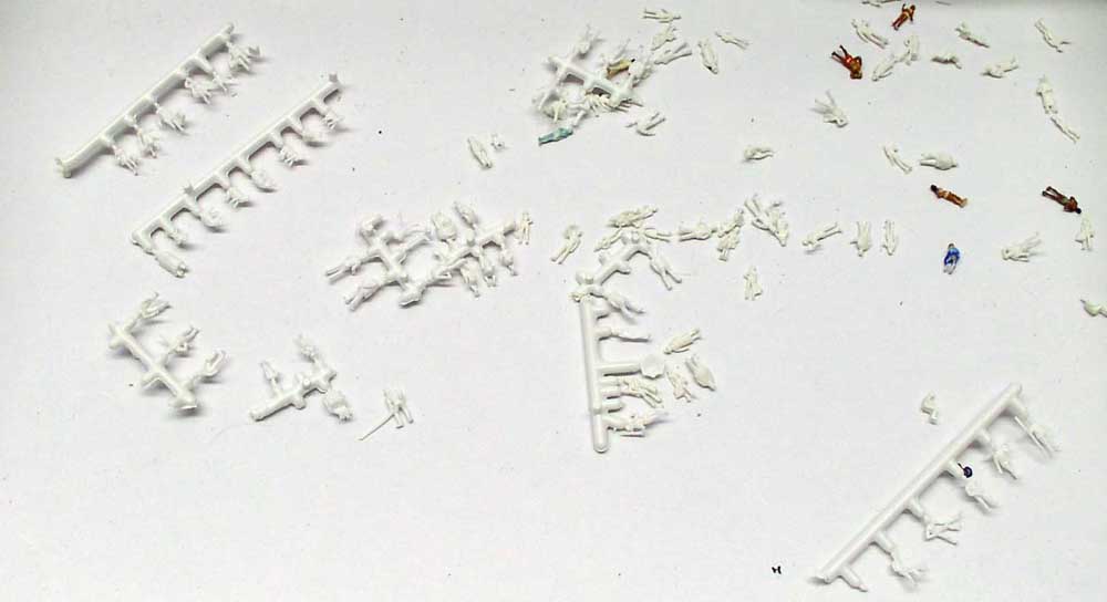 Petites figurines de personnages en plastique blanc sur grappes, certaines peintes, pour maquette