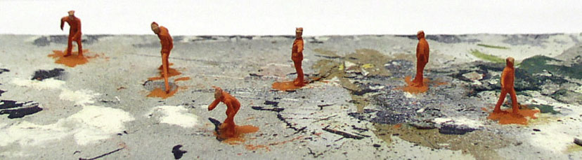 Figurines miniatures orange peintes posées sur un socle de diorama en cours de réalisation