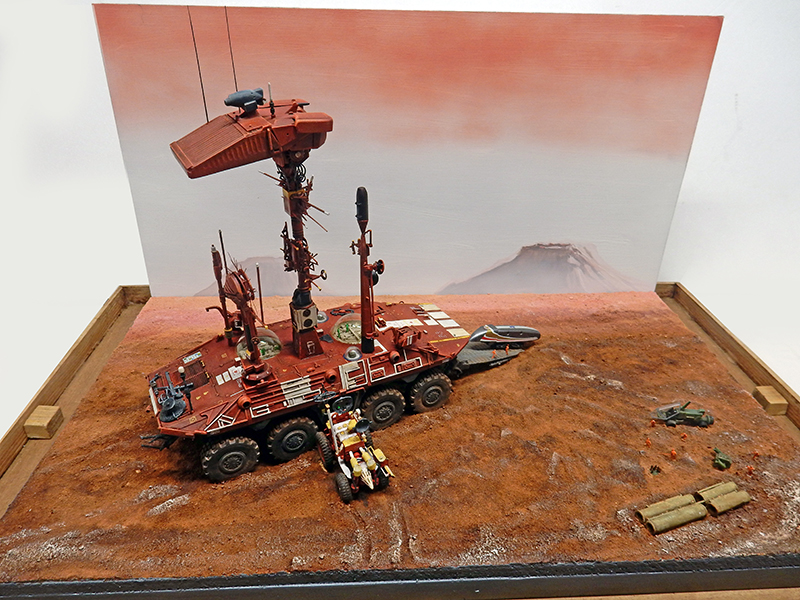 Diorama du transporteur martien à huit roues avec moto devant un paysage rouge de Mars