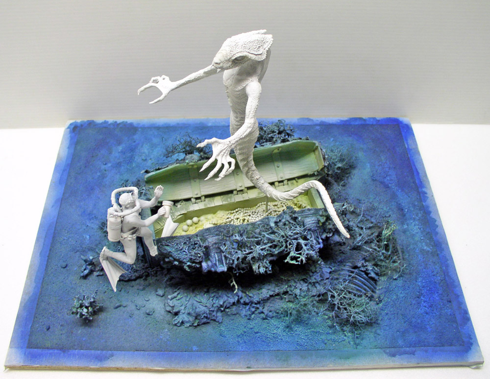 Diorama sous-marin avec démon marin blanc menaçant un plongeur près d'une épave