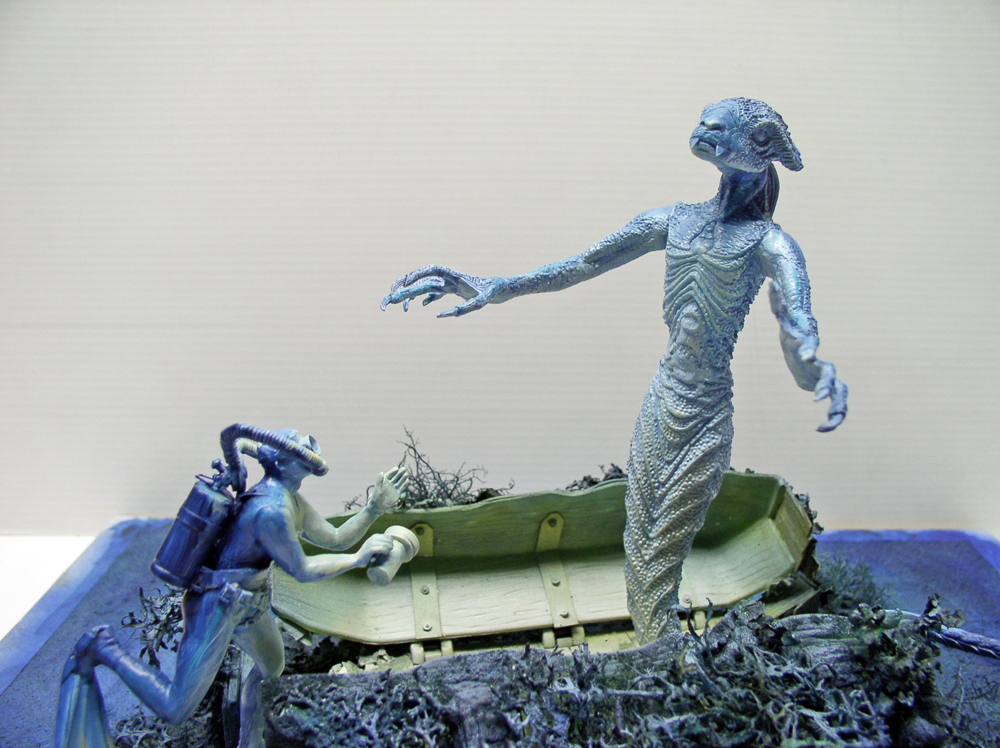 Diorama d'un démon marin bleuté surgissant d'une barque face à un plongeur