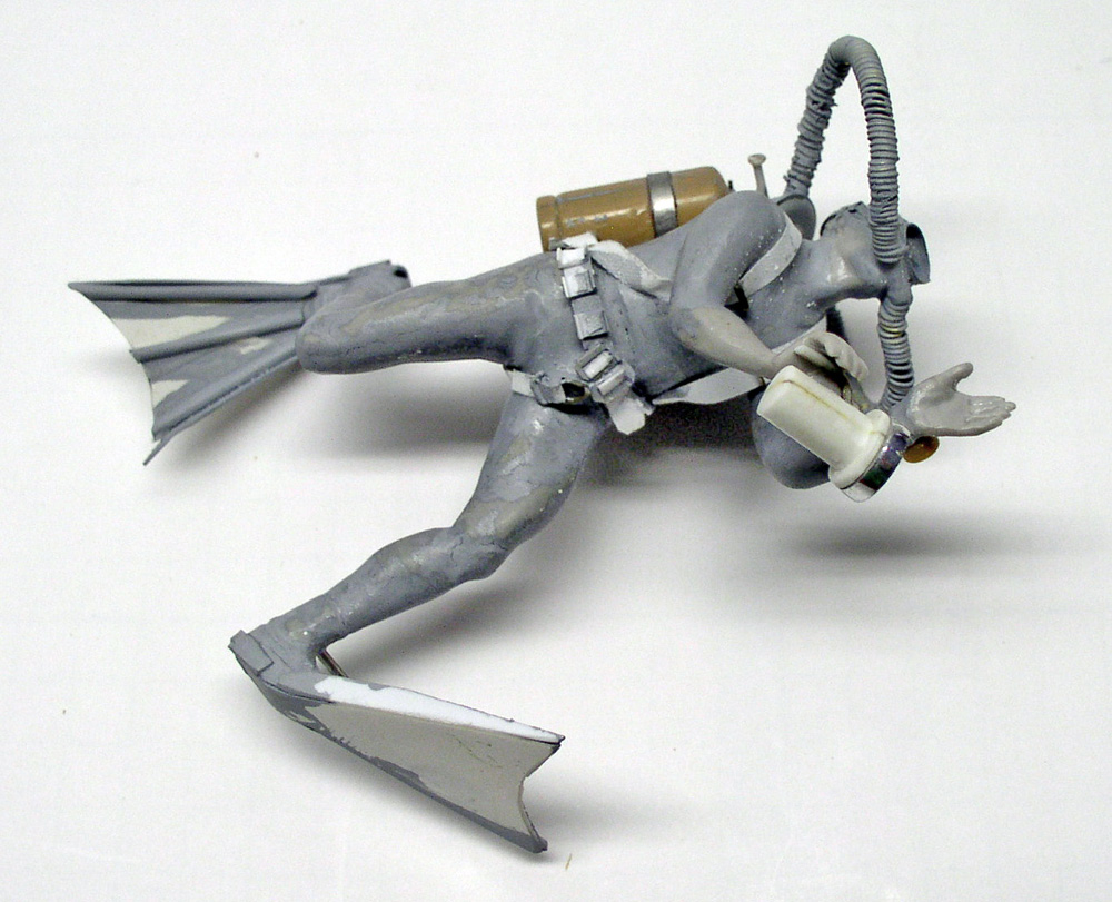Figurine de plongeur sous-marin en résine grise avec palmes, bouteille et détendeur, en cours de montage