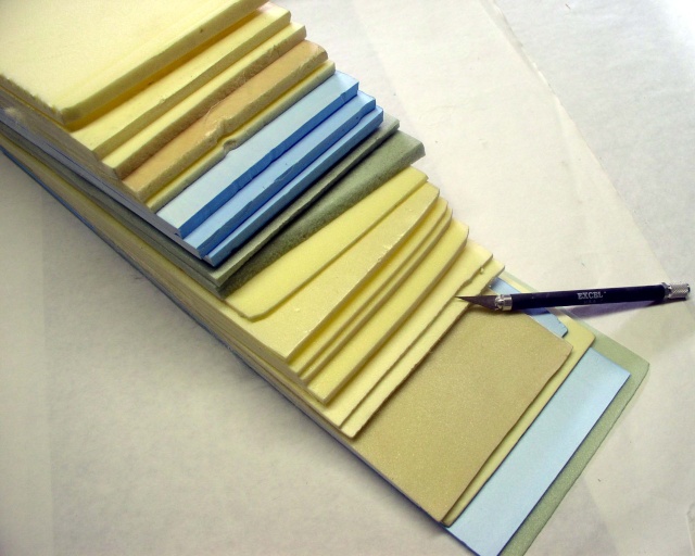Empilement de plaques de polystyrène extrudé multicolores découpées en escalier avec un cutter de précision