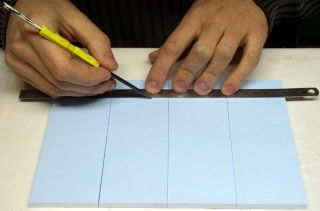 Tracé de lignes parallèles au crayon sur une plaque de polystyrène extrudé bleu avec une règle