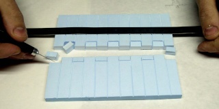 Application de colle au pinceau sur des bandes de polystyrène extrudé bleu découpées