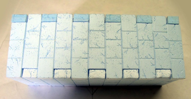 Bloc de polystyrène extrudé gravé et peint en bleu imitant un mur de pierres