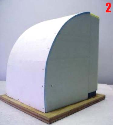 Structure courbe en polystyrène extrudé recouverte de carton blanc montée sur socle en bois