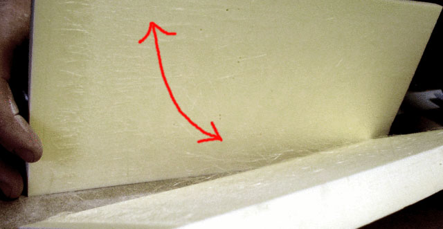Plaque de polystyrène extrudé pliée à la main avec flèche rouge indiquant le mouvement