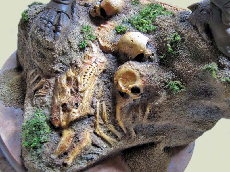 Crânes et ossements émergeant du sol sablonneux d'un diorama Predator avec mousse végétale