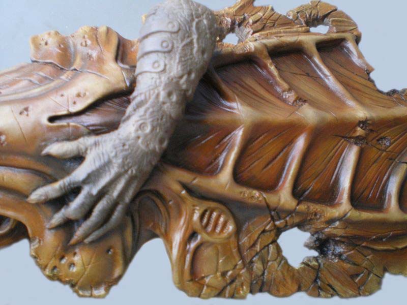 Détail de la main griffue du Predator posée sur son dos écailleux brun