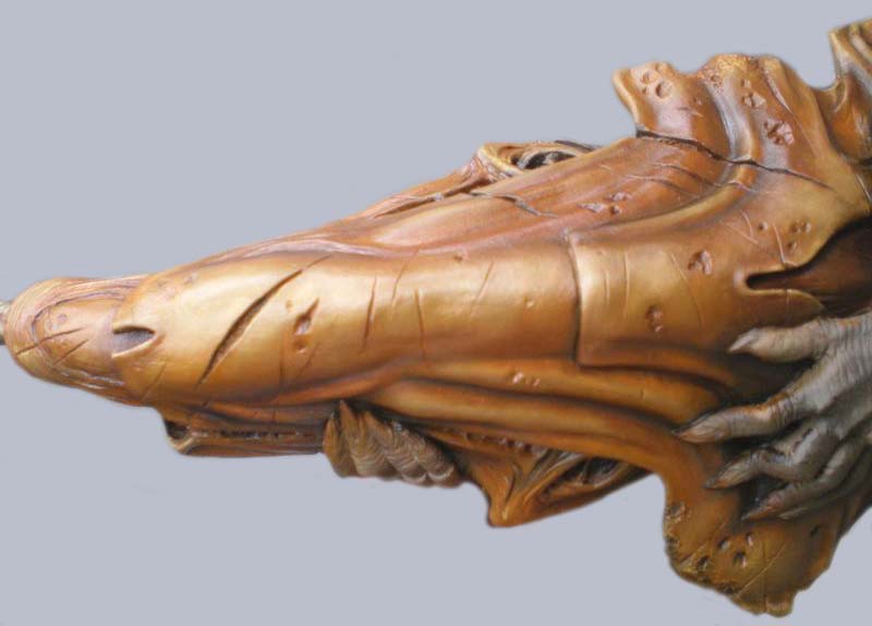 Crâne biomécanique de profil peint en tons cuivrés avec mandibules détaillées de la maquette Predator