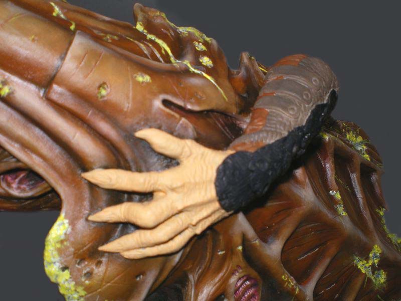 Gros plan sur la main griffue et la peau texturée d'une maquette Predator peinte