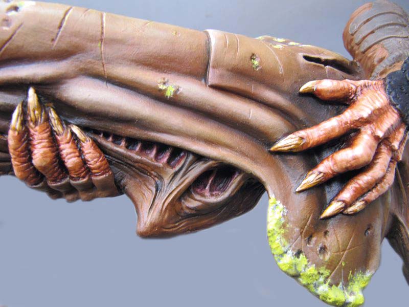 Gros plan sur les mains griffues et le tronc d'une figurine Predator peinte