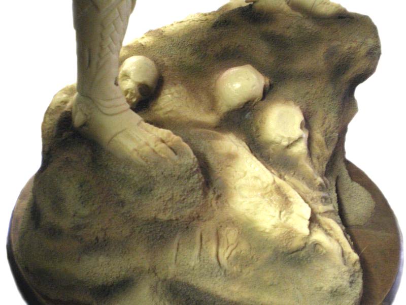 Socle de diorama Predator avec crânes sculptés émergeant du sol rocheux non peint
