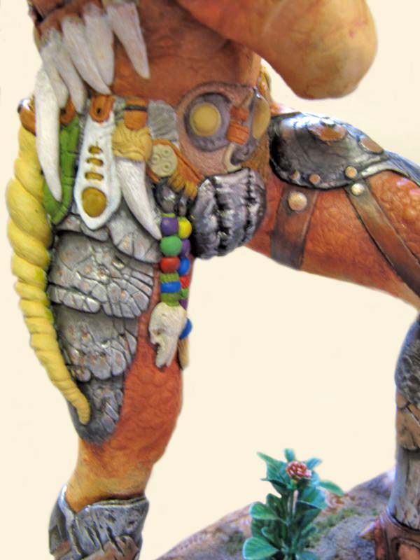 Détail de la figurine Predator montrant armure, crocs, perles colorées et peau écailleuse sur la jambe