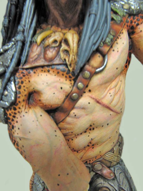 Détail du torse peint de la figurine Predator avec crâne trophée et bandoulière
