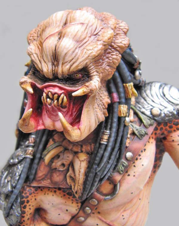 Buste de Predator peint montrant le visage aux mandibules ouvertes et dreadlocks