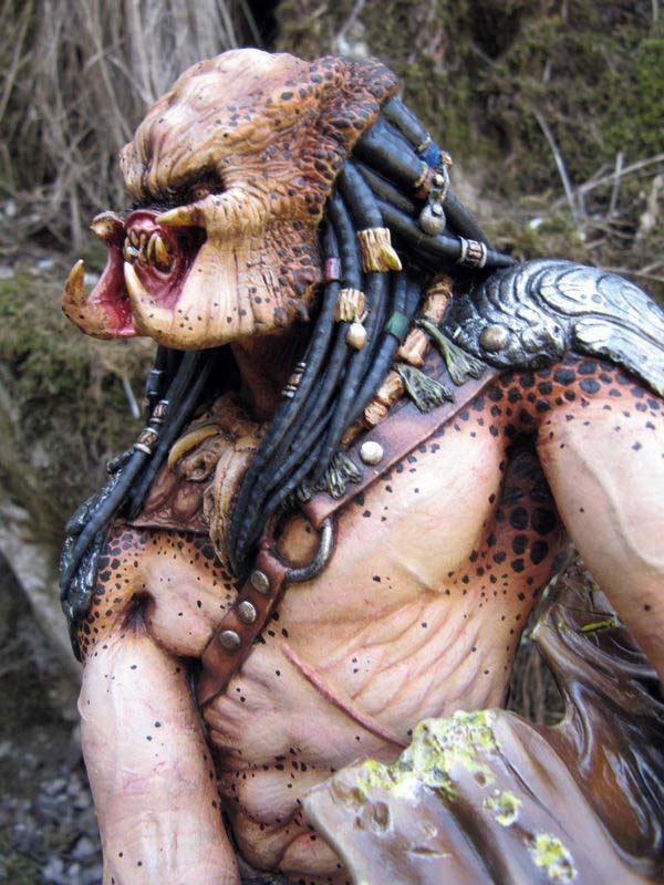 Profil de la figurine Predator mâchoires ouvertes montrant dreadlocks épaisses et peau tachetée peinte