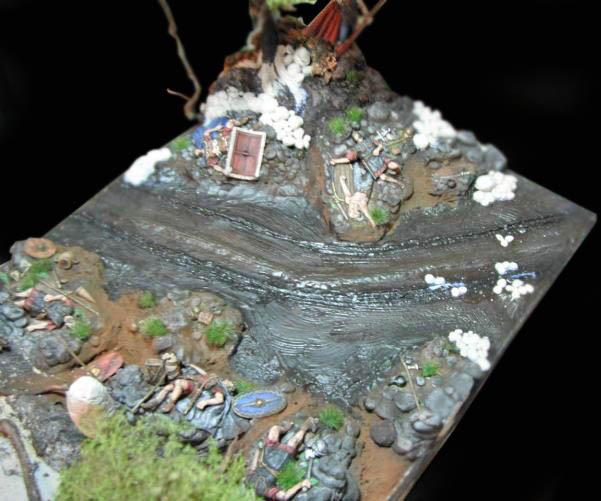 Diorama de scénette romaine avec rivière, soldats peints, rochers et végétation sur terrain modelé