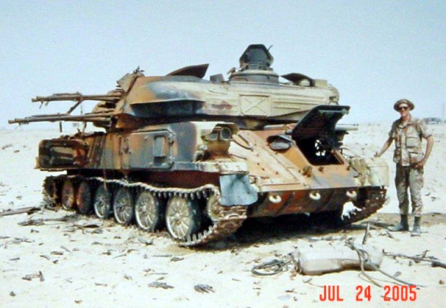 Épave d'un char antiaérien Shilka ZSU-23-4 dans le désert avec un soldat