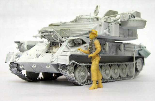 Maquette du char antiaérien Shilka en apprêt gris avec figurine de tankiste jaune non peinte