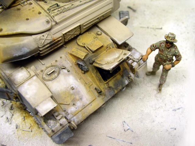 Figurine de soldat en tenue camouflée à côté de la maquette Shilka sur diorama sablonneux