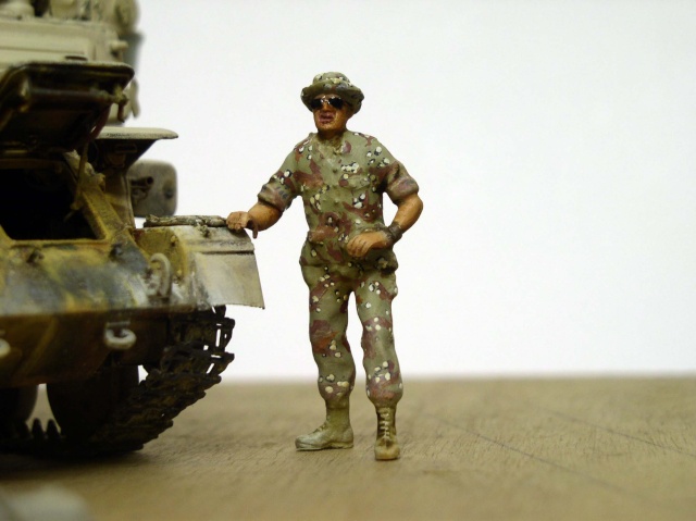 Figurine de soldat en tenue camouflée posant près de la maquette Shilka