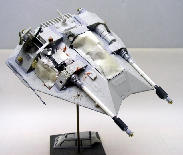 Maquette de Snowspeeder peinte avec dégâts de combat et canons latéraux, montée sur socle