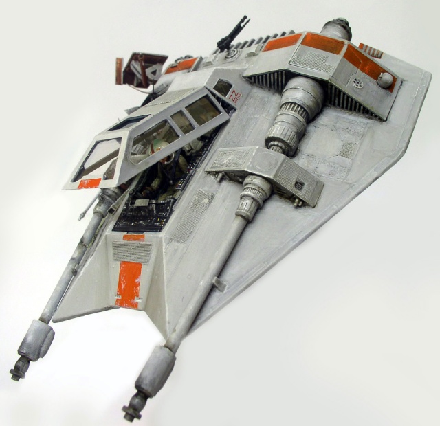 Maquette de Snowspeeder gris vieilli aux marquages orange, cockpit ouvert, vue trois quarts