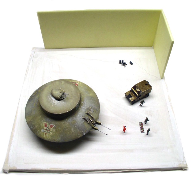 Maquette de soucoupe volante INGSOC posée sur un diorama avec véhicule blindé et figurines