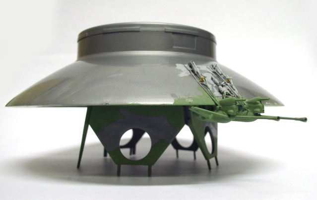 Maquette de soucoupe volante grise avec train d'atterrissage vert et canons latéraux montés