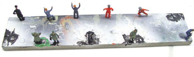Figurines de soldats miniatures peintes disposées sur un socle gris allongé pour diorama