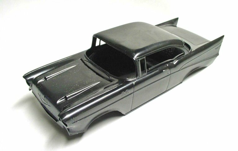 Voiture miniature Space Chevy en cours de montage posée sur un plan de travail