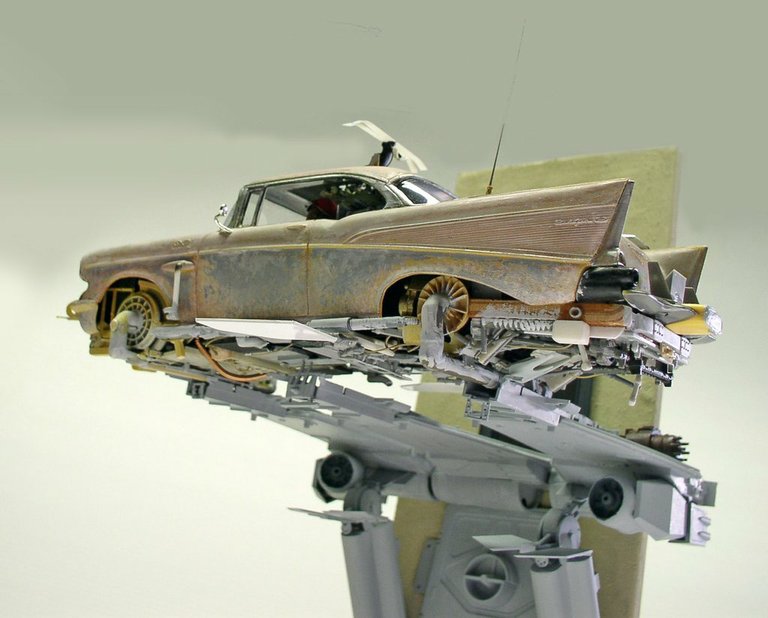 Maquette de Chevy rouillée transformée en vaisseau spatial posée sur un support futuriste