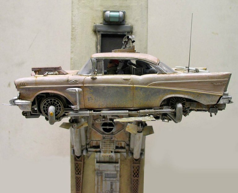 Maquette de Chevrolet 1957 volante vieillie posée sur un socle futuriste, vue latérale