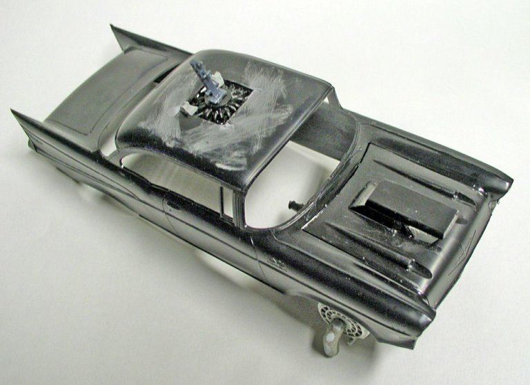 Voiture miniature Space Chevy peinte posée sur un support de maquettiste