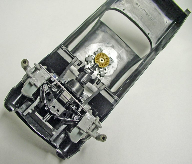 Châssis de maquette Space Chevy retourné montrant mécanisme moteur détaillé et structure intérieure peinte