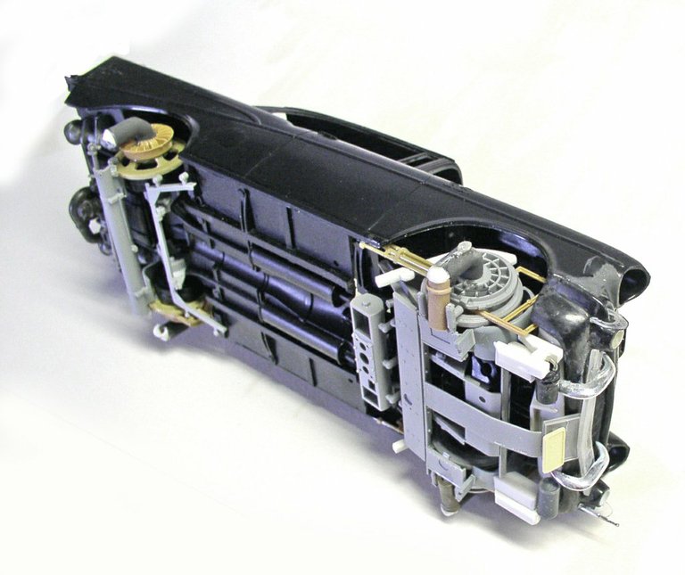 Dessous de la maquette Space Chevy montrant le châssis violet et les détails mécaniques en gris