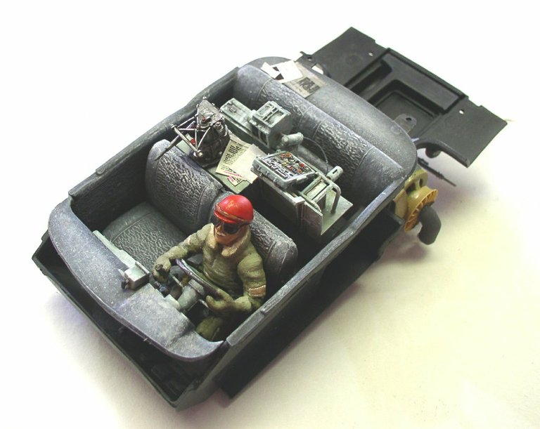 Cockpit de la maquette Space Chevy avec figurine de pilote au casque rouge et tableau de bord détaillé