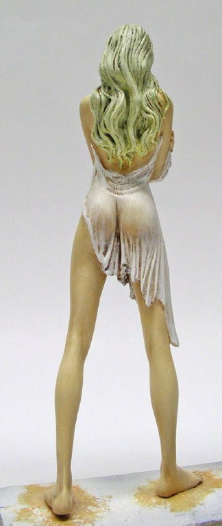 Figurine peinte d'une femme aux longs cheveux verts, vue de dos, vêtue d'une robe blanche