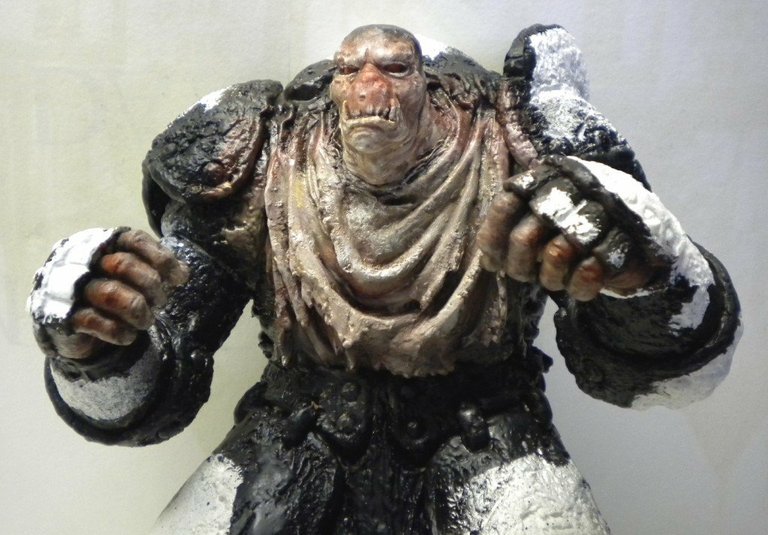 Figurine peinte d'un guerrier monstrueux musclé en armure sombre, poings serrés