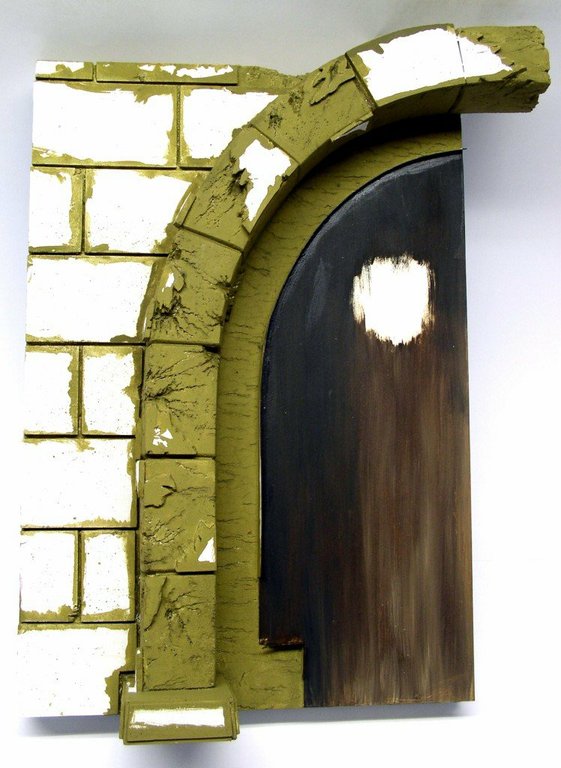 Décor de socle en cours avec mur de briques et arche en pierre encadrant une porte