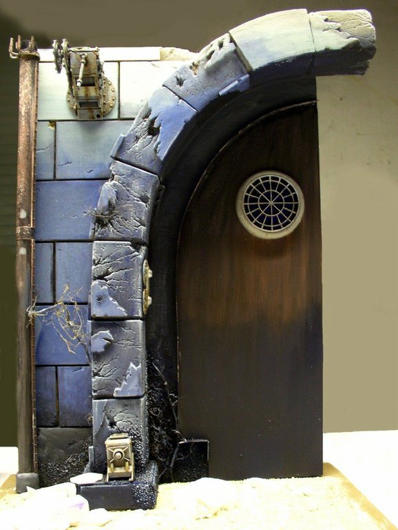 Décor de socle en pierre avec arche, mur de briques bleues et porte voûtée