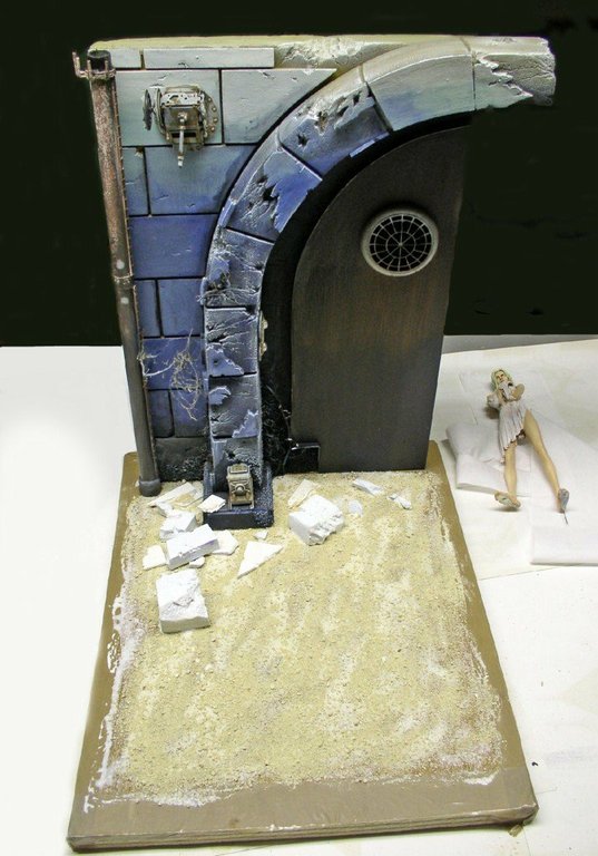 Décor de diorama mur de pierre bleuté avec porte voûtée et figurine peinte en cours