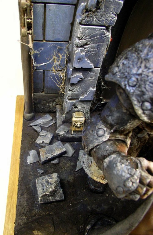 Diorama de figurine peinte avec sol pavé brisé et coffret doré près d'un mur en pierre
