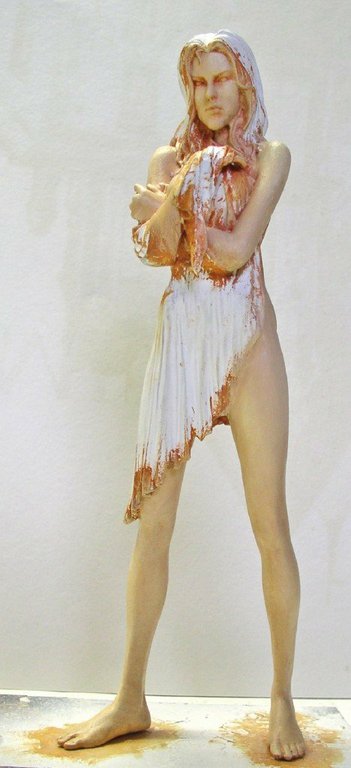 Figurine peinte d'une femme aux longs cheveux vêtue d'une robe blanche déchirée