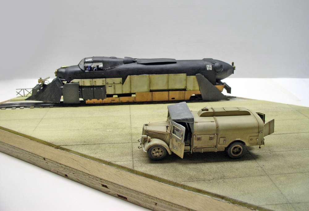 Maquette de train blindé allemand noir sur rails avec camion-citerne militaire beige sur diorama